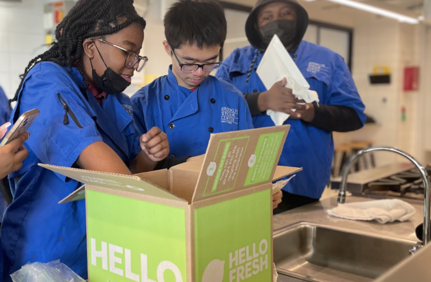 Two team members pack HelloFresh donation boxes to bring meals to those in need